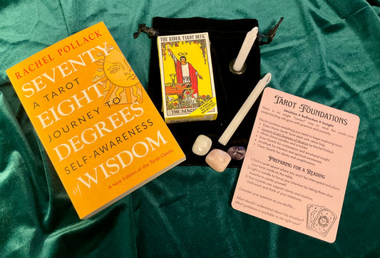 Tarot books, cards, and tools on a green fabric background