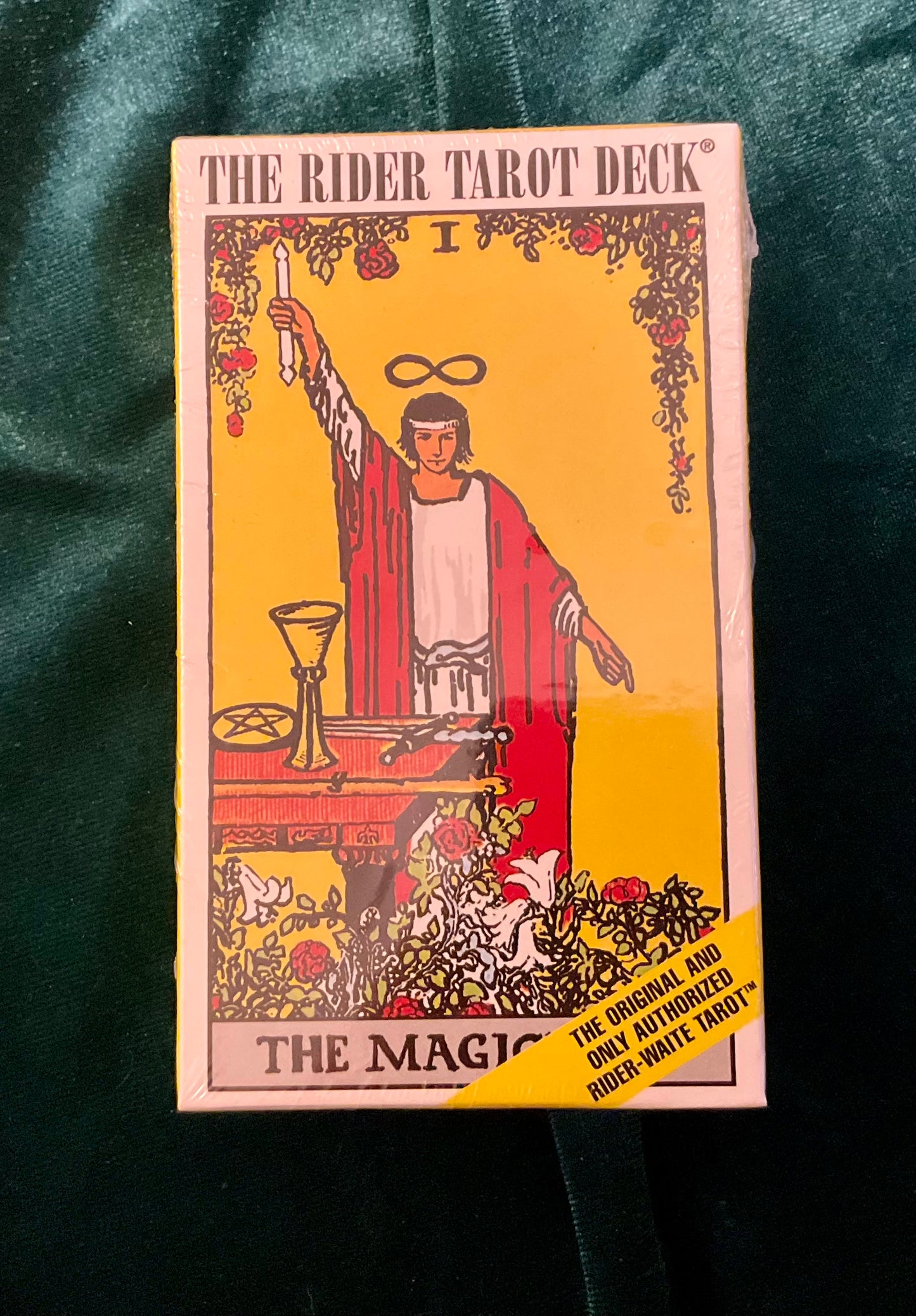 Rider Tarot Deck packaging with a person in red robes holding a sword on a yellow background.